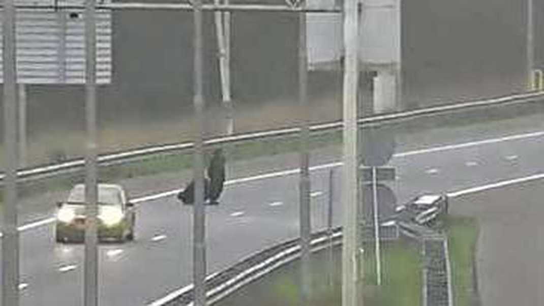 (VIDEO) Man steekt met koffers snelweg over, krijgt boete van politie