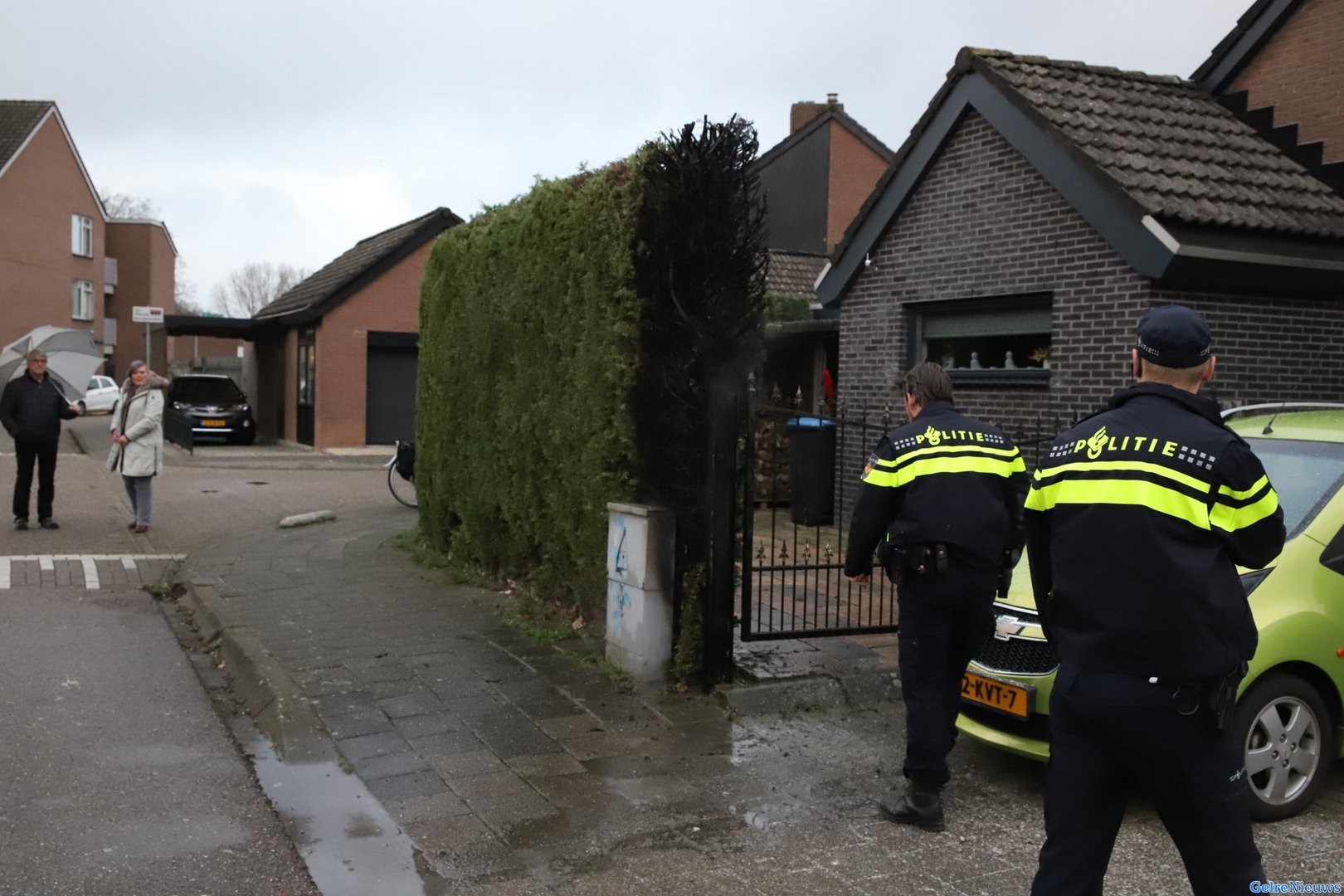 Buurtbewoner blust brand met water uit regenton in Tiel