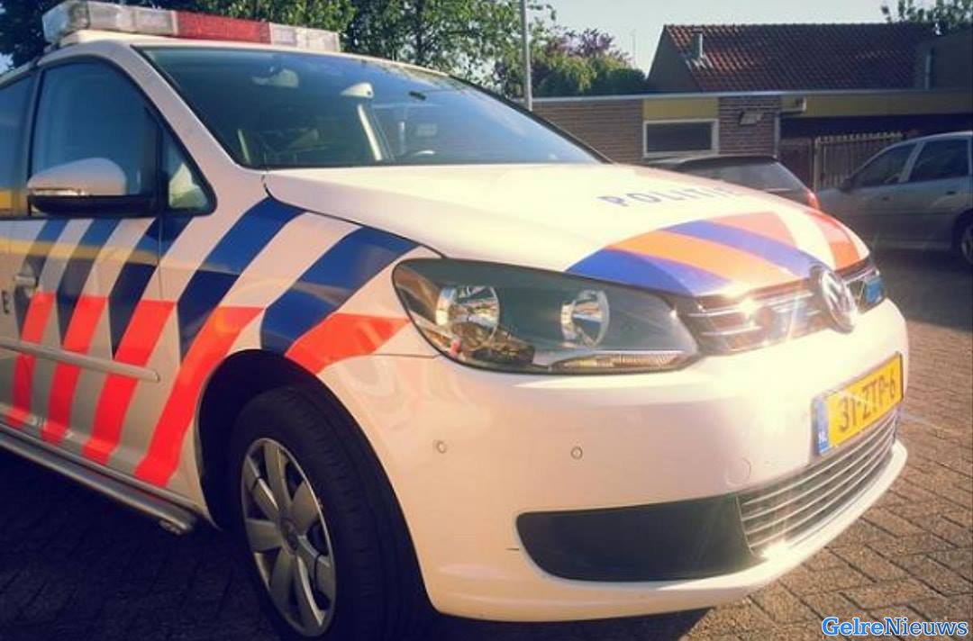 Politie komt bij dienstvoertuig, jongeman staat er tegen aan te plassen
