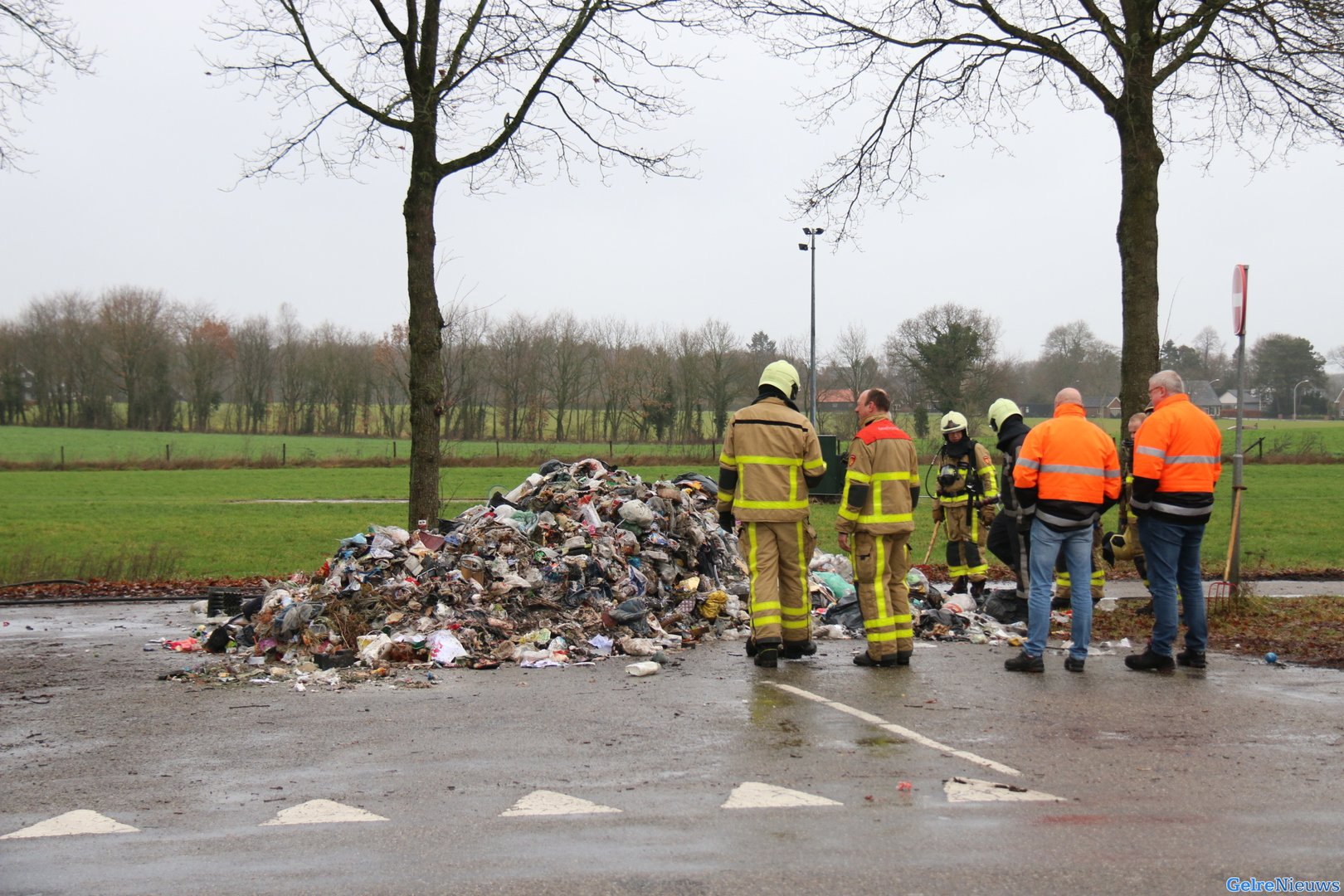 Rook uit vuilniswagen door carbid, vuilnis op straat gekiept