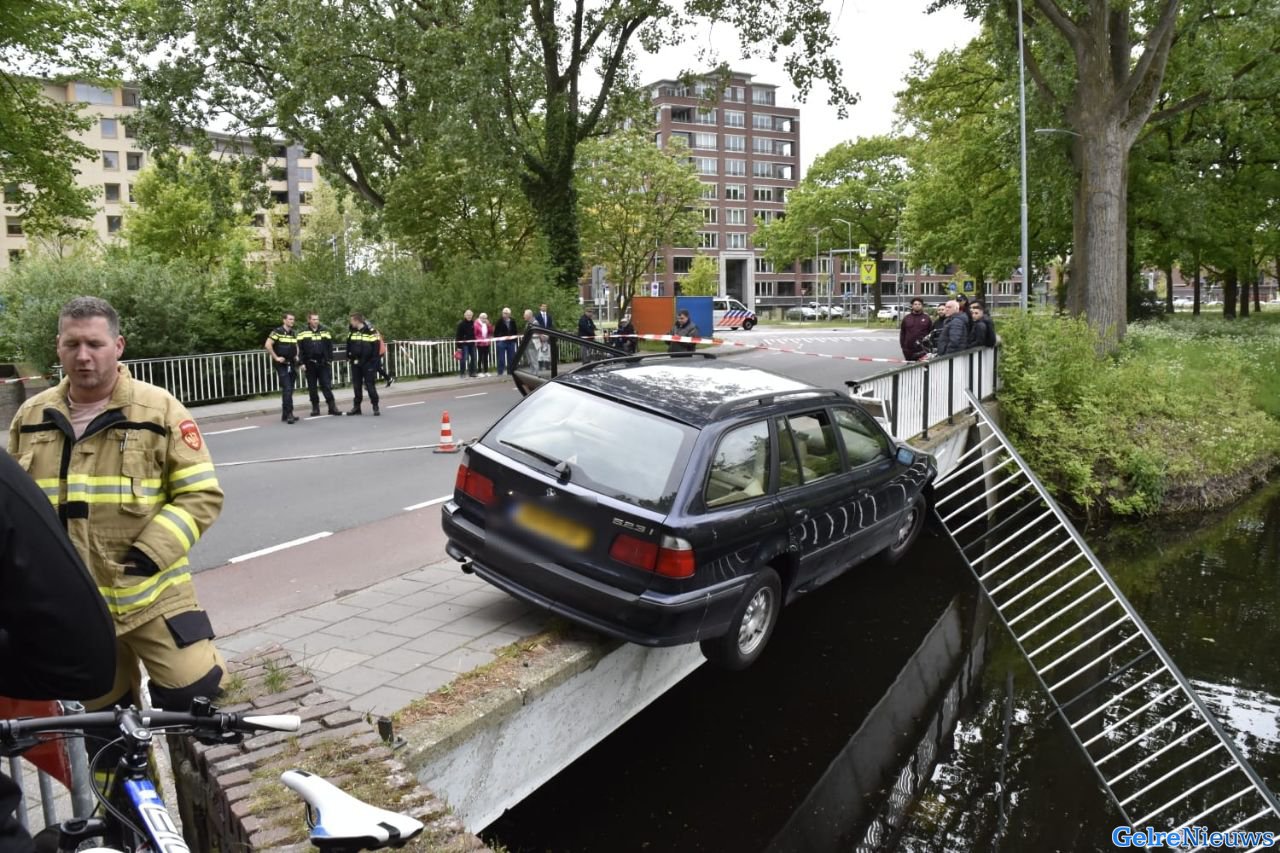 Auto ramt reling en balanceert boven het water