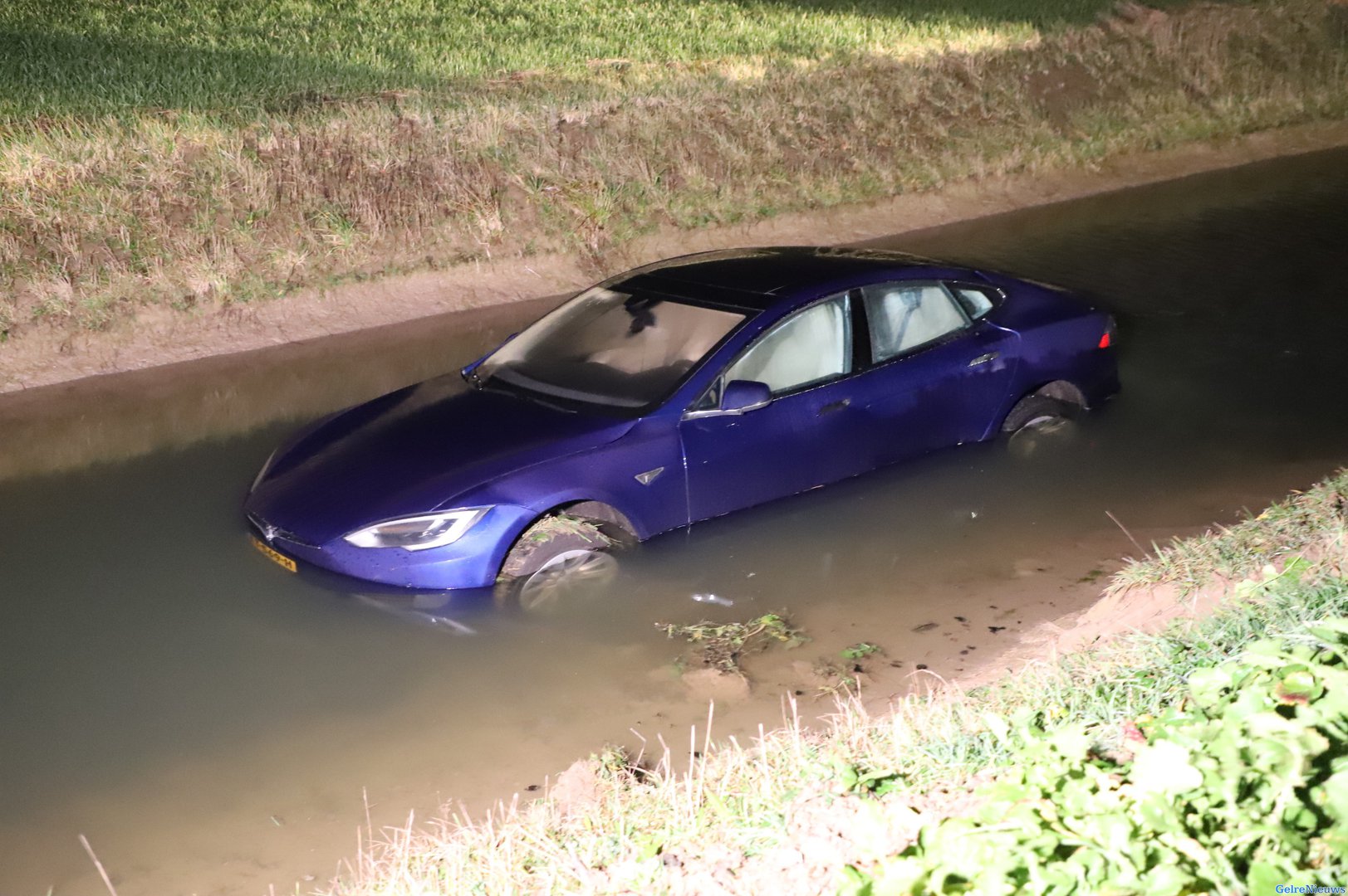 Gloednieuwe Tesla rijdt een sloot met water in