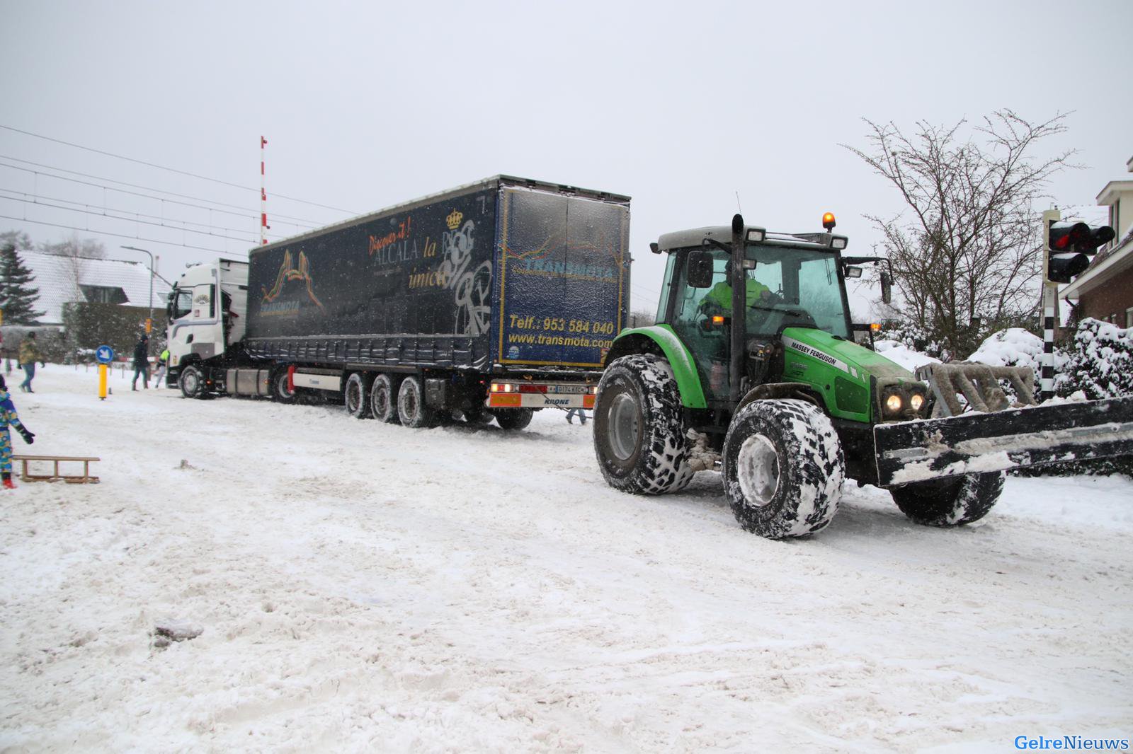 Tractor trekt vrachtwagen los na vastrijden op spoorwegovergang Rheden