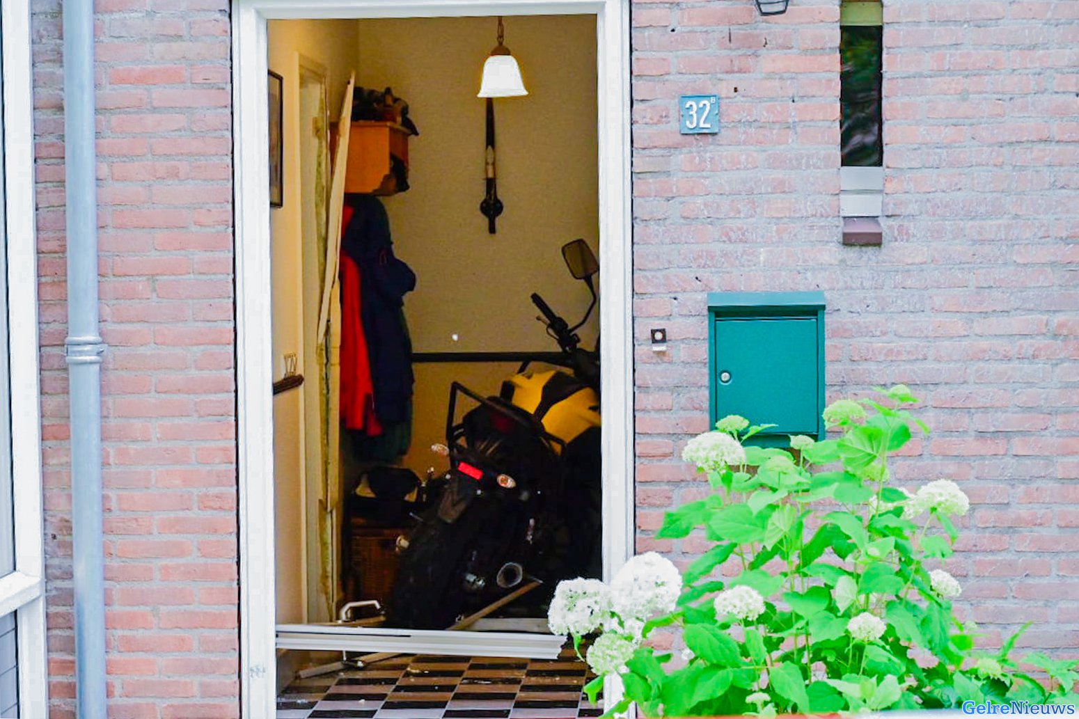 Lesmotor rijdt door de voordeur een woning binnen