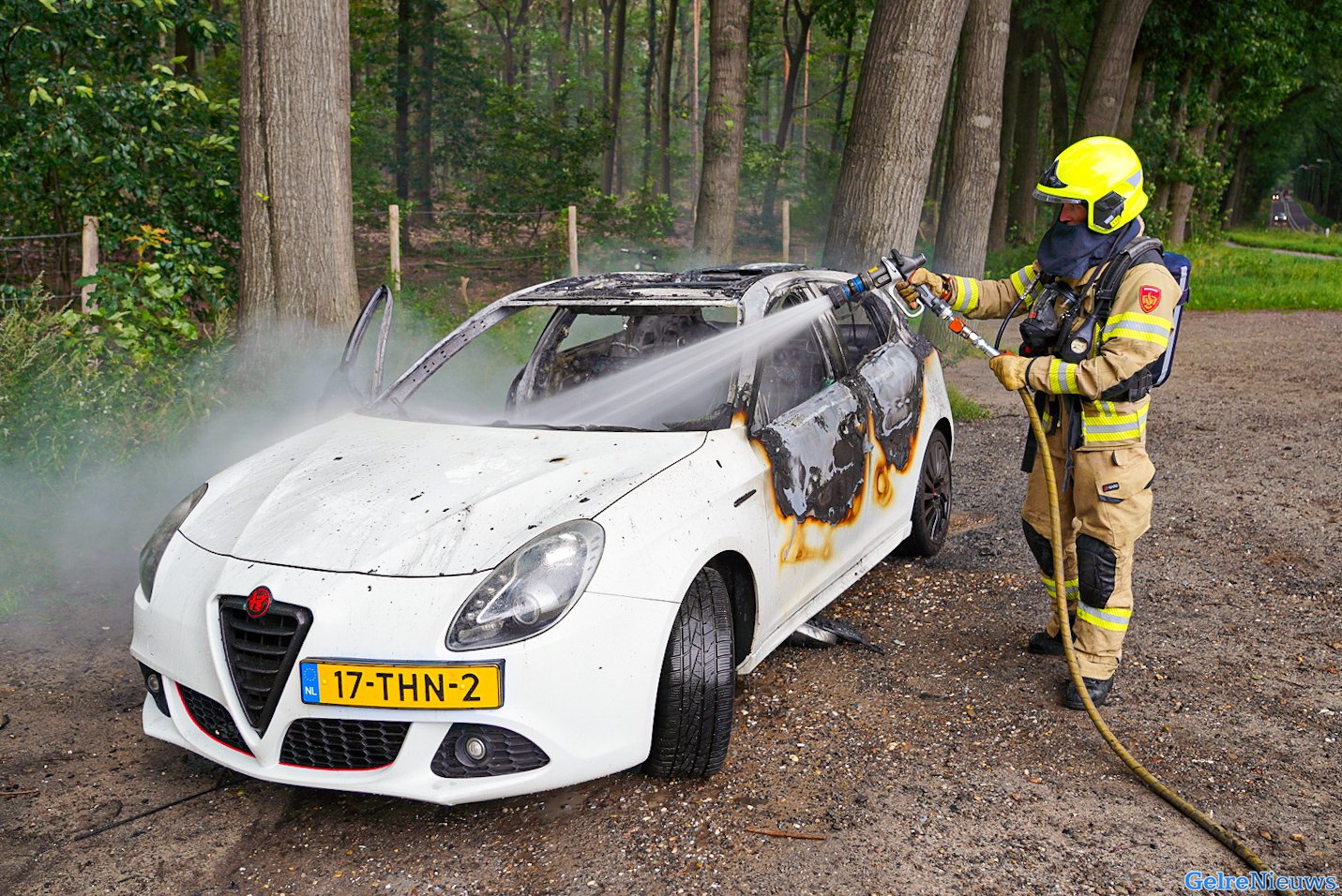 Auto brandt volledig uit op parkeerplaats bij het bos