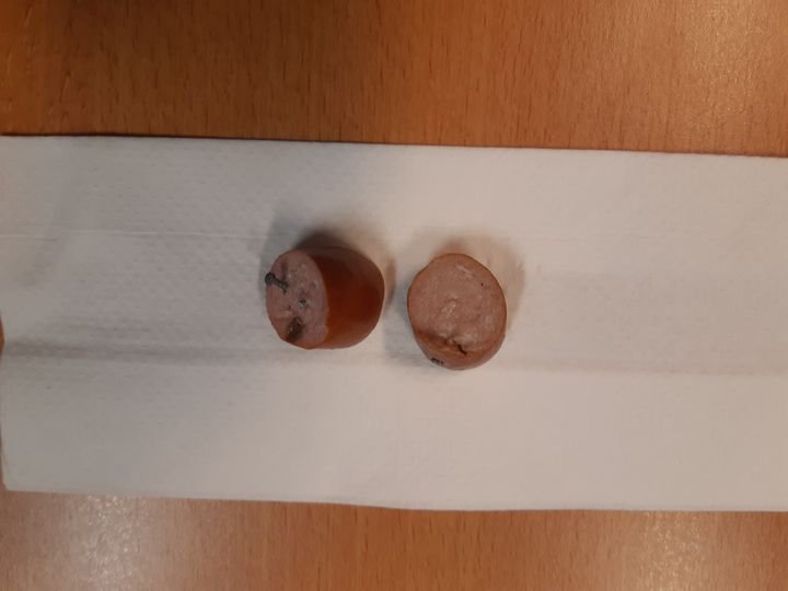 Hond eet worst met spijkers erin