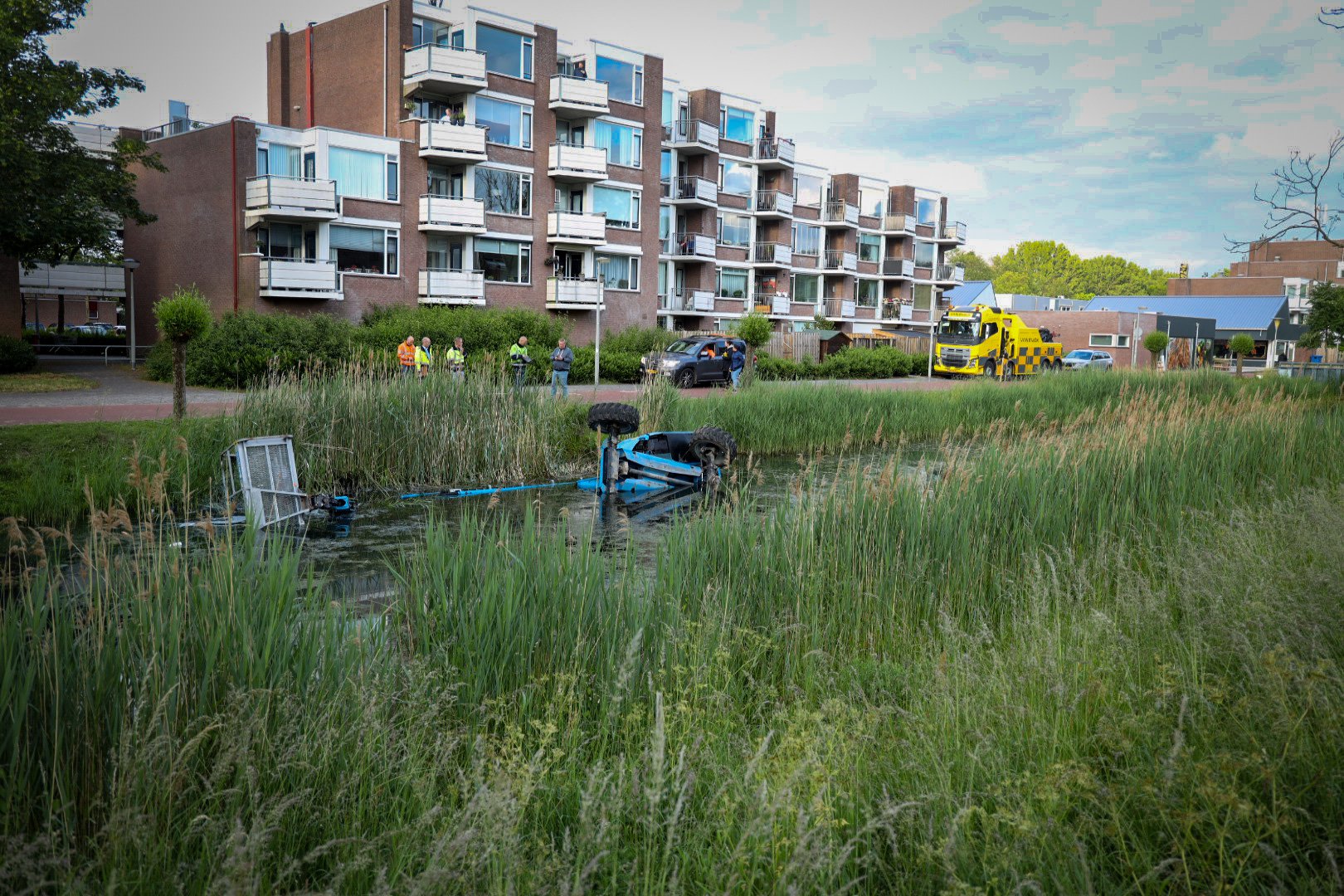 Schilder met hoogwerker glijdt van talud en belandt in sloot