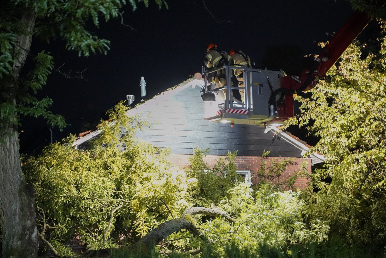 Tak breekt af en valt tegen woning