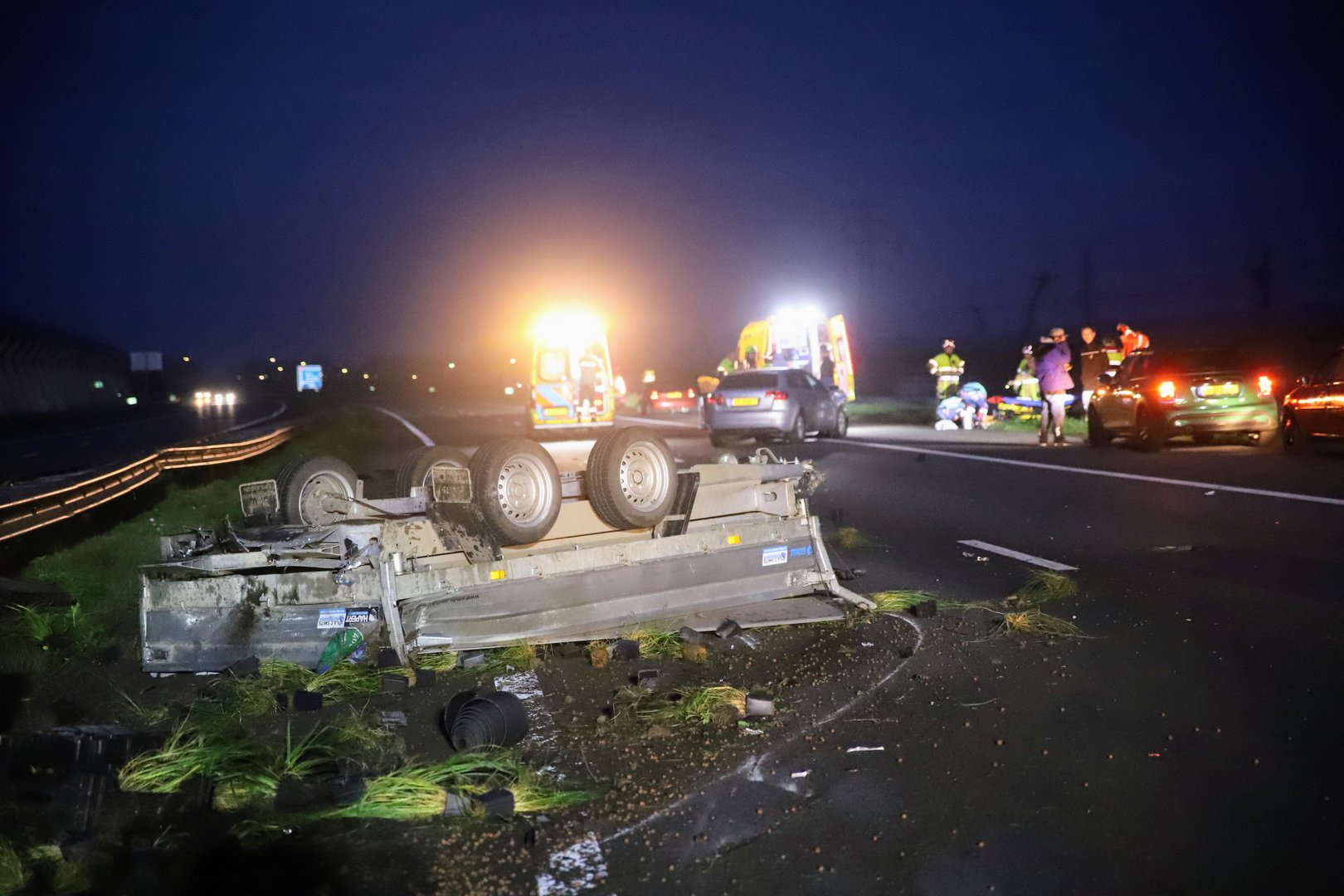 Aanhanger slaat over de kop op A15; voorbijgangers halen bestuurder uit rokende auto