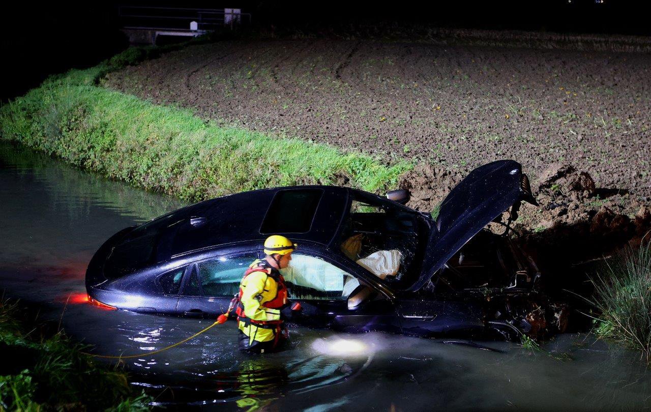 Dure BMW belandt in het water, bestuurder naar het ziekenhuis