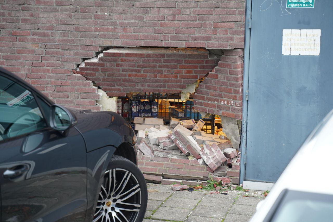 Automobilist ramt gevel van supermarkt