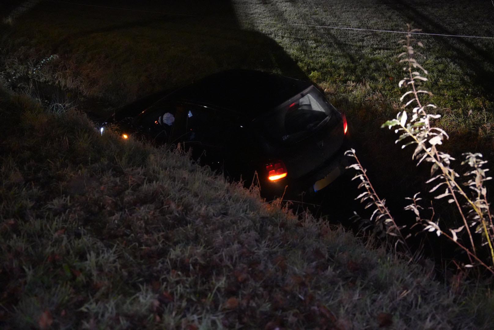 Auto belandt in sloot, bestuurder gered door agent