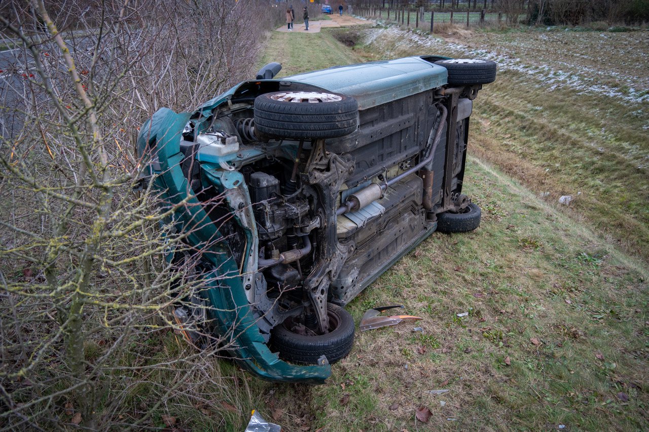 Auto over de kop geslagen, bestuurder gewond