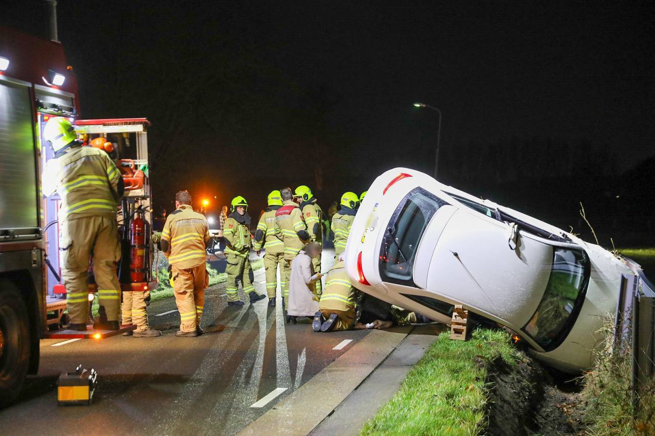 Vrouw kijkt op haar mobiel en raakt van de weg