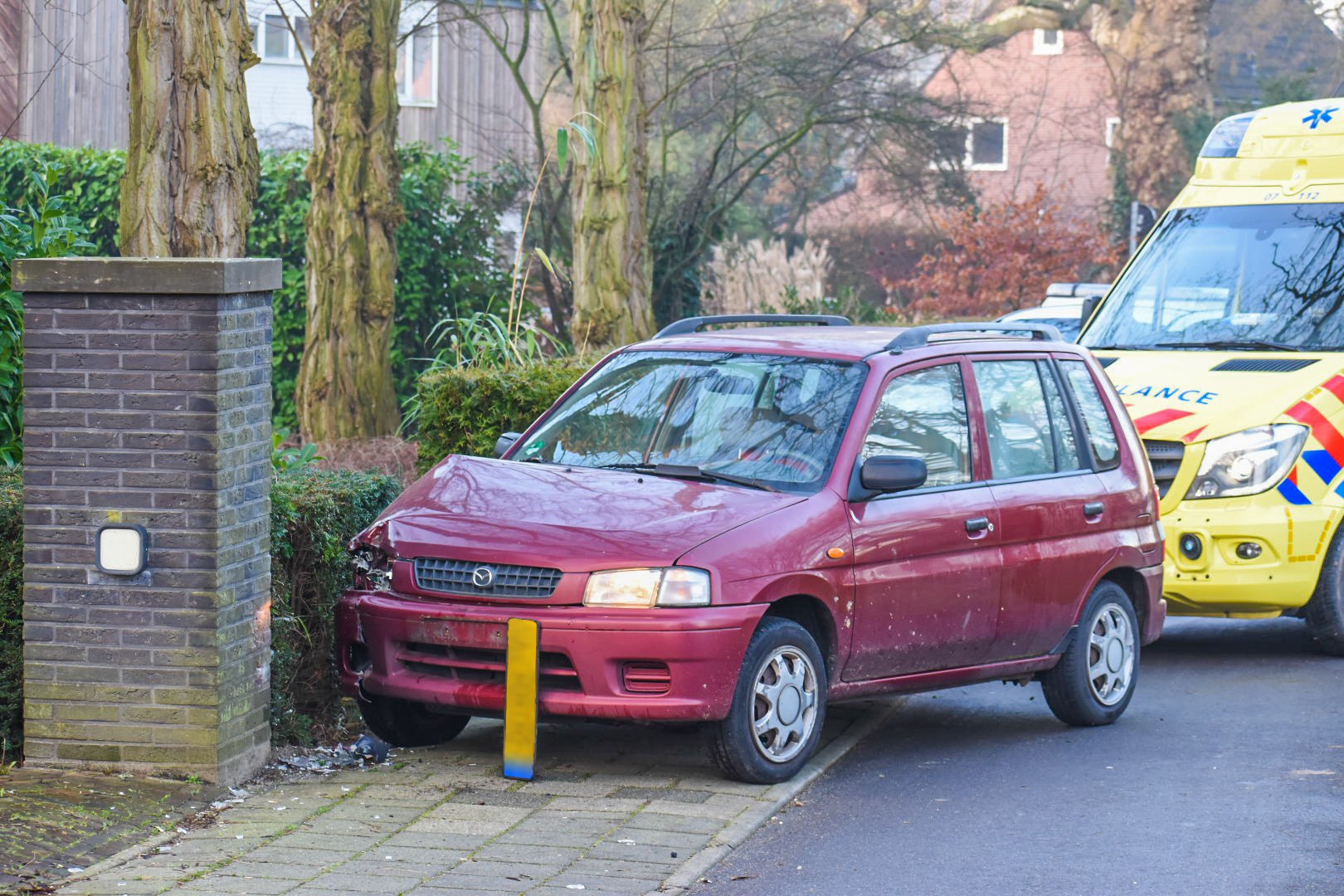 Auto raakt van de weg en botst tegen pilaar van tuin