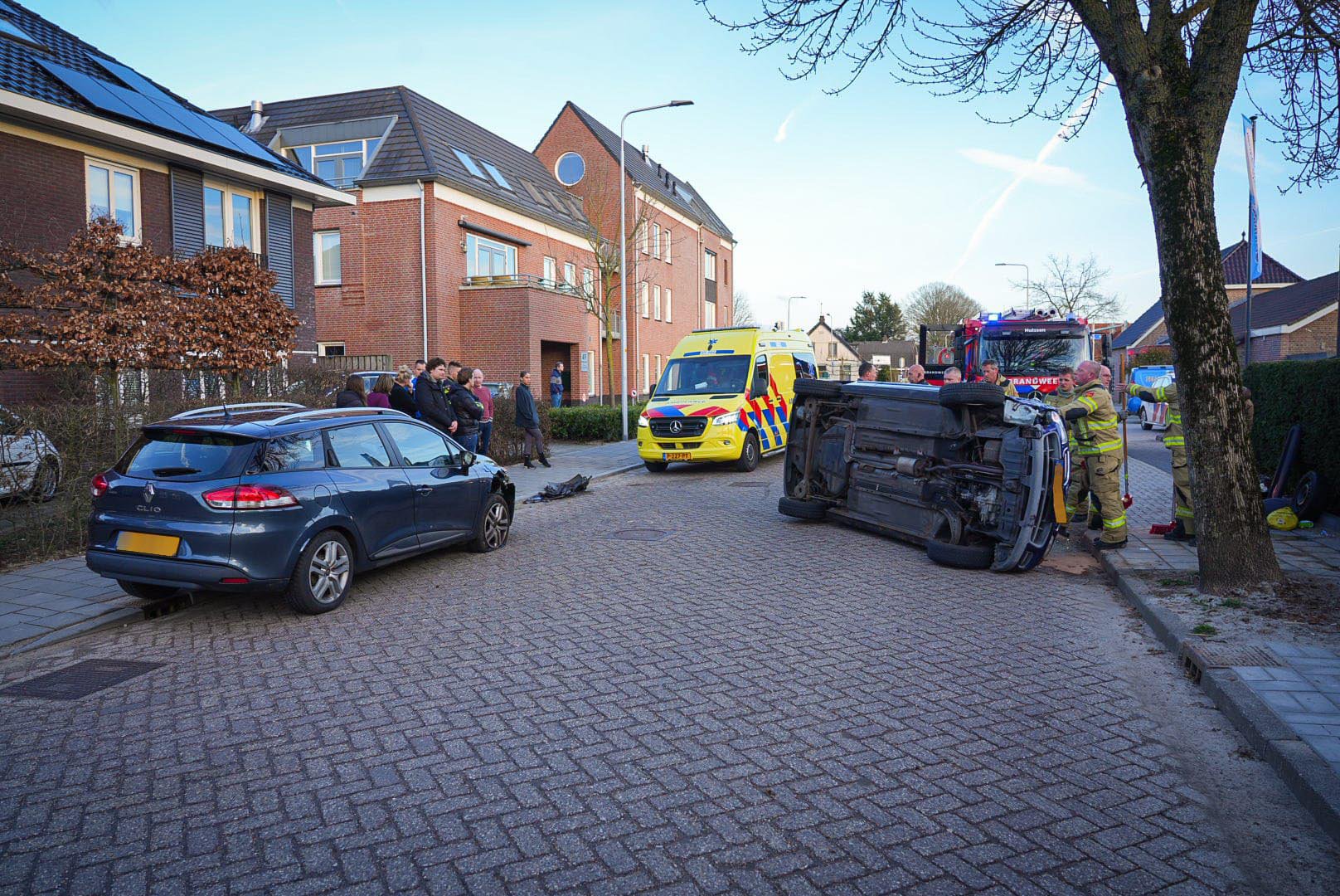 Automobilist botst op geparkeerde auto en komt op zijkant terecht