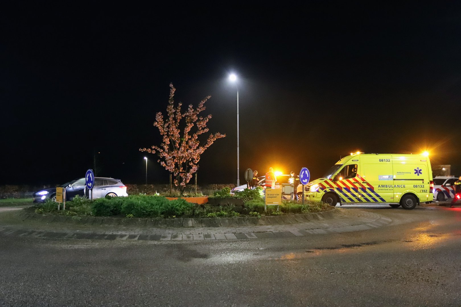 Auto crasht tegen lantaarnpaal en rotonde