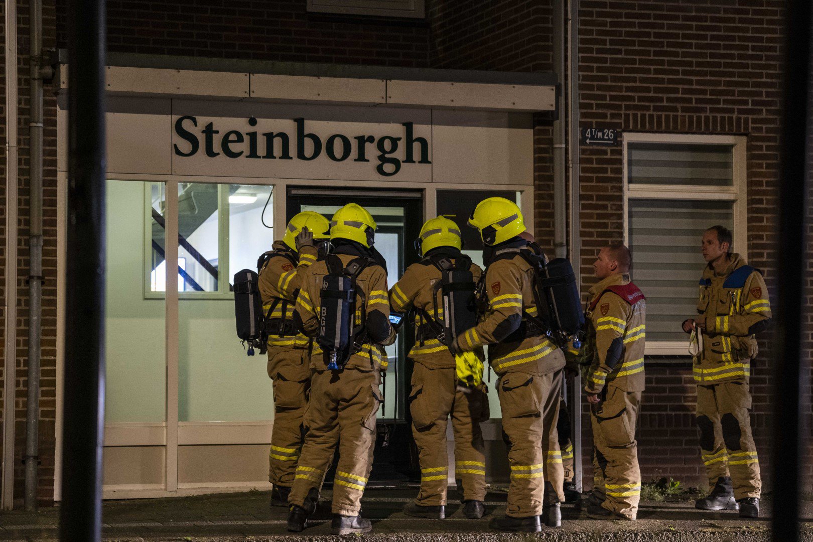 Bewoners met vluchtmasker op geëvacueerd bij vreemde lucht in gebouw