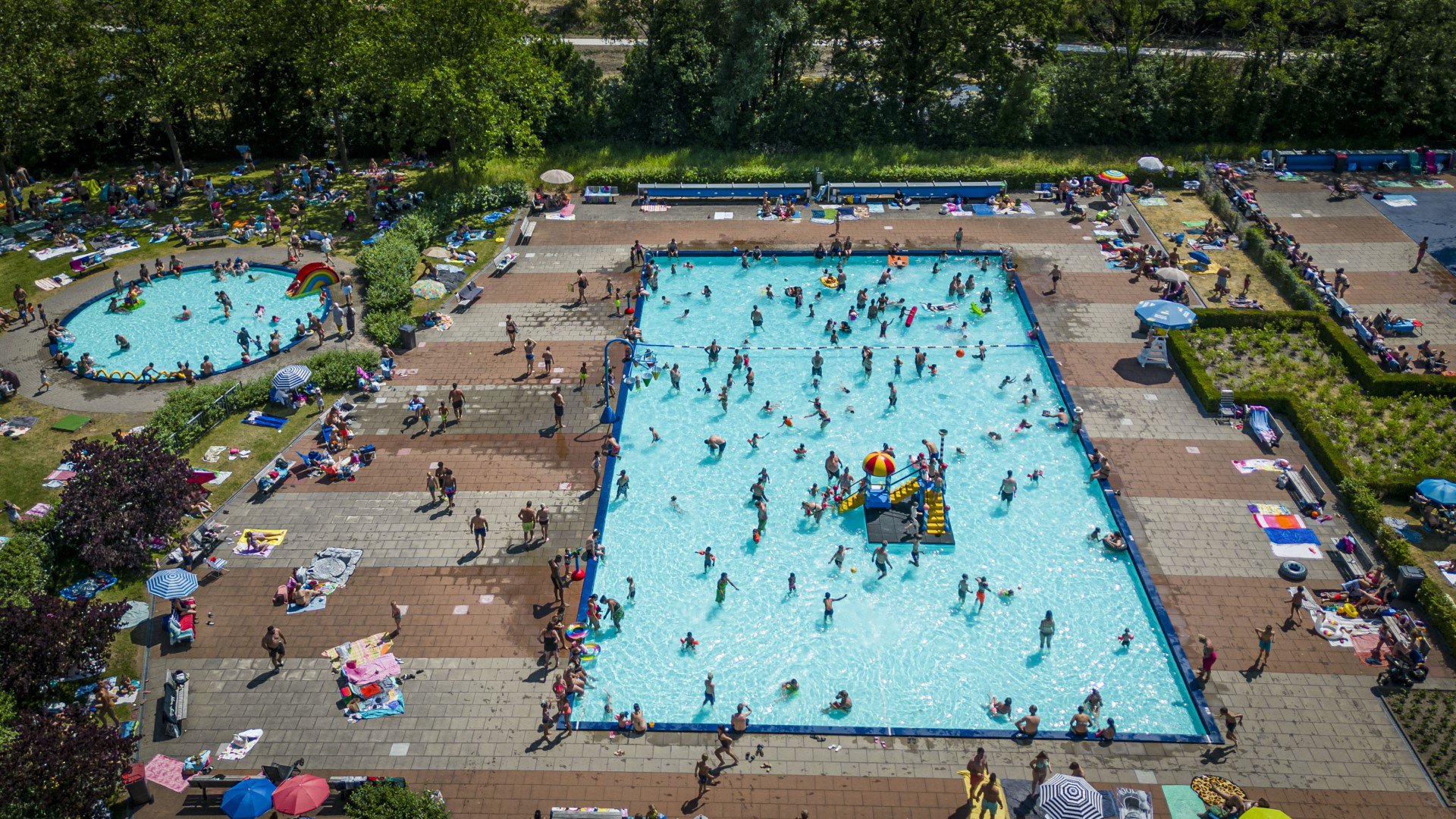Mensen zoeken verkoeling bij openluchtzwembad in Rheden