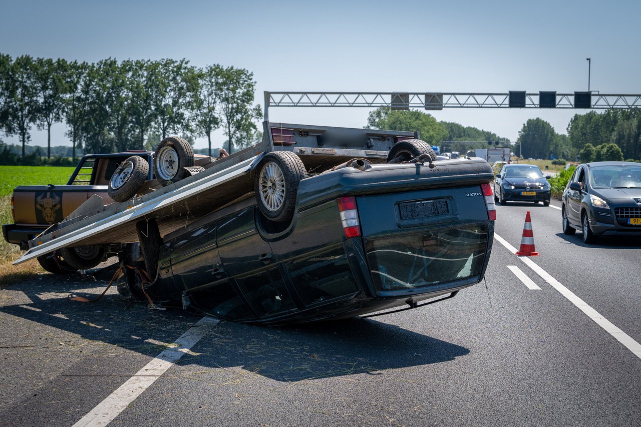Invoegen gaat mis, aanhanger belandt op zijn kop op de A12