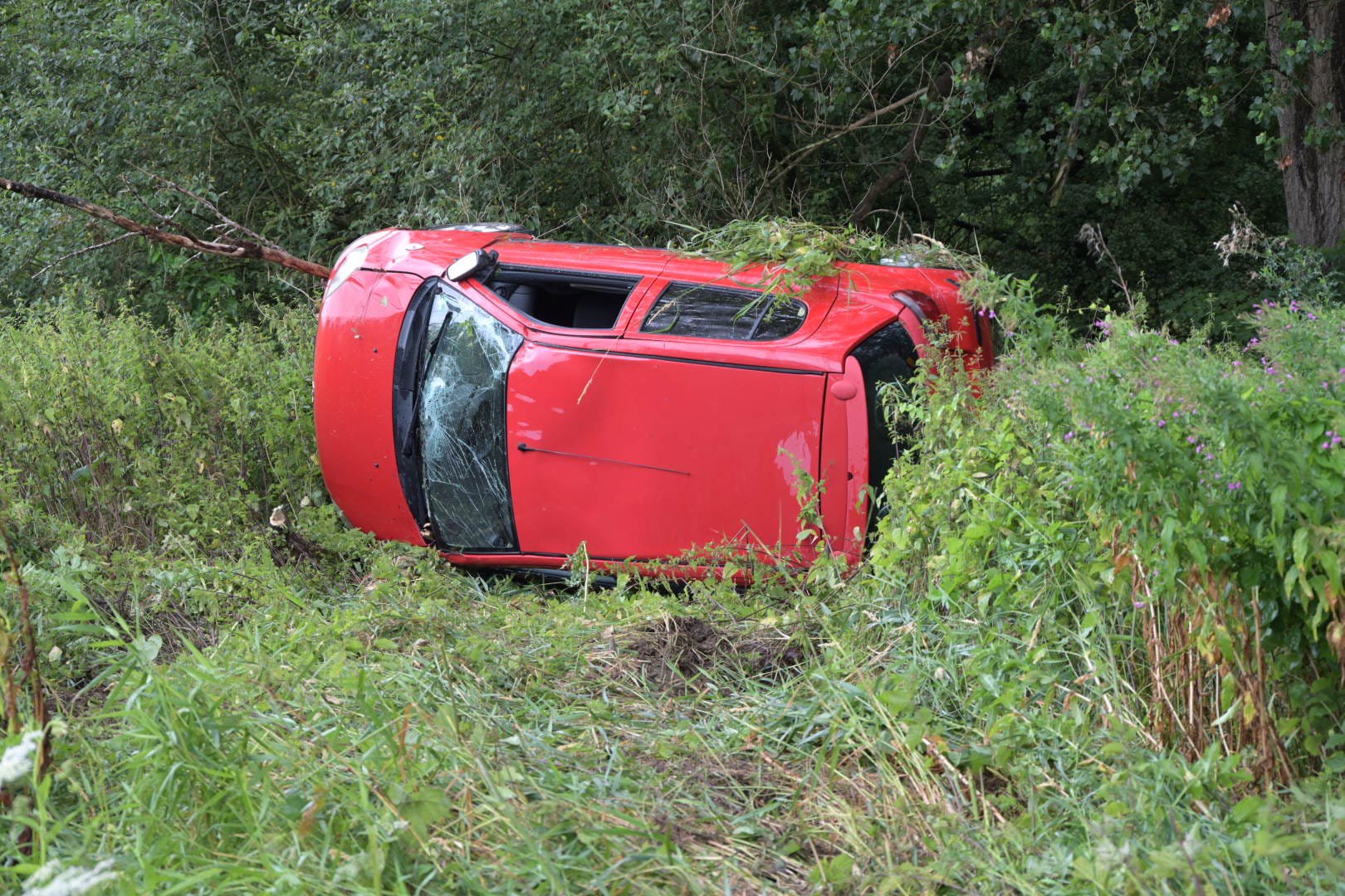 Automobilist raakt van de weg en komt op zijkant tot stilstand in bosschages
