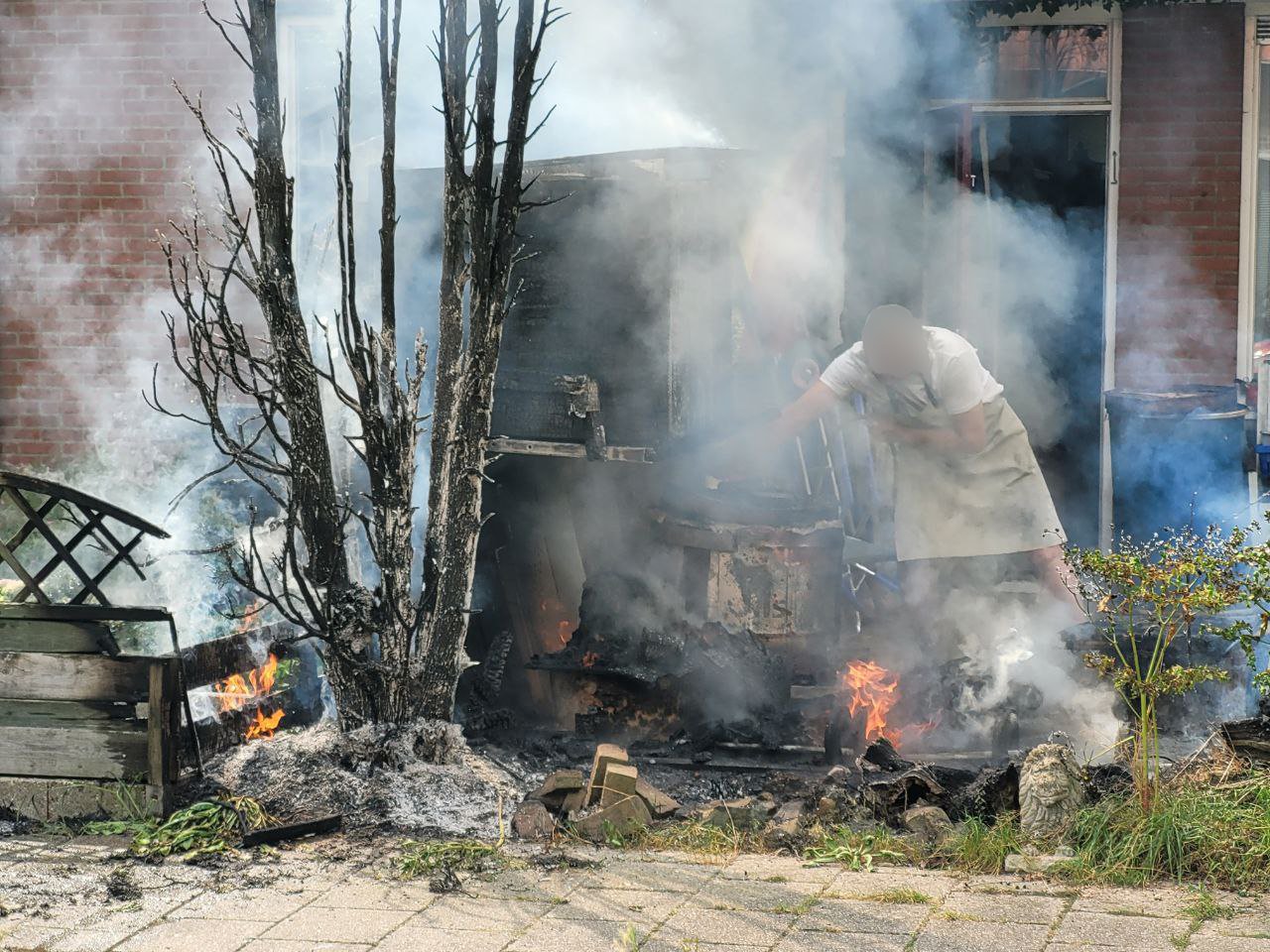 Bewoner probeert met tuinslang buitenbrand te blussen in Rheden