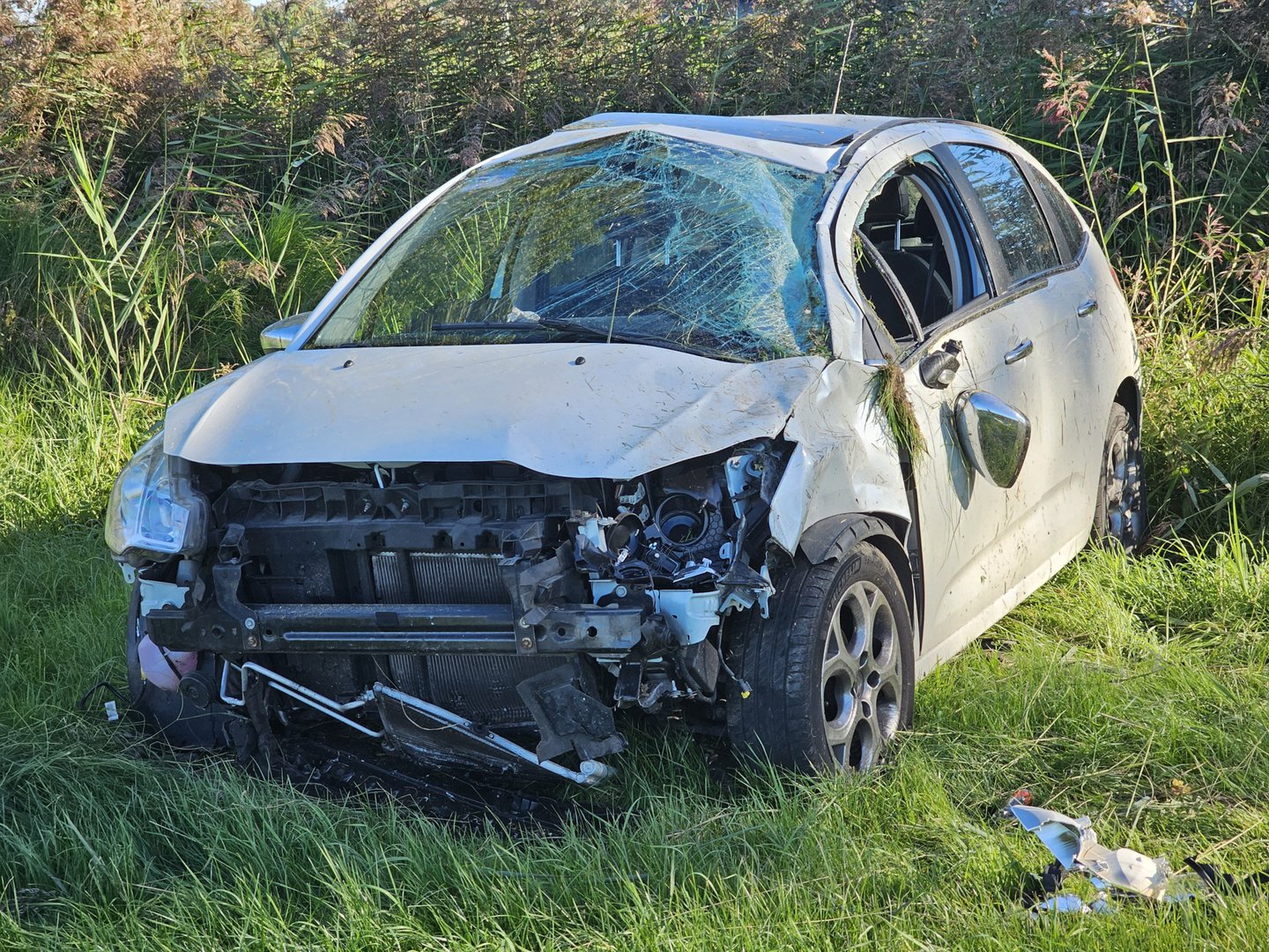 Auto vliegt over de kop en belandt in weiland