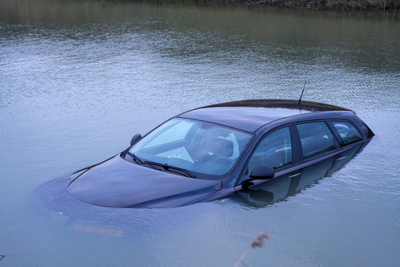 Handrem vergeten, auto rolt water in