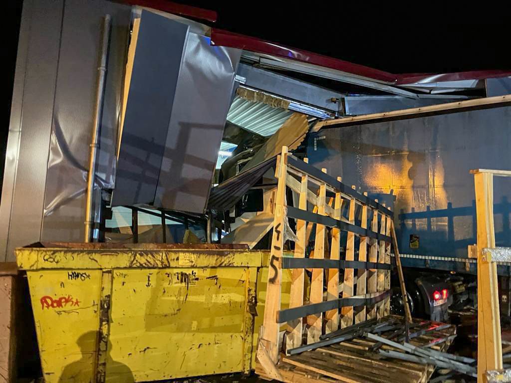 Vrachtwagen rijdt bedrijfspand binnen, hulpdiensten rukken groots uit