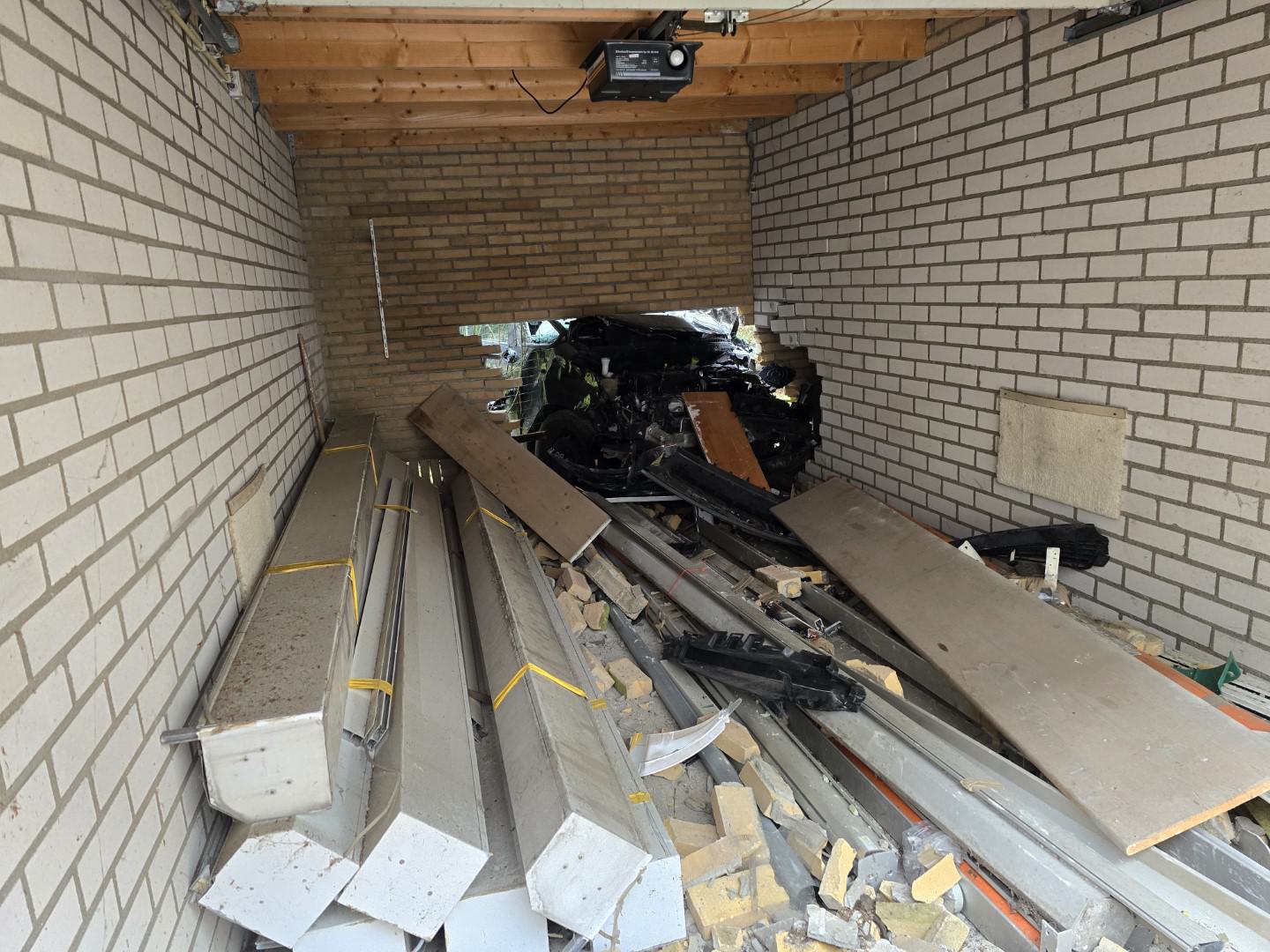 Auto ramt vanaf parkeerplaats door muur garage