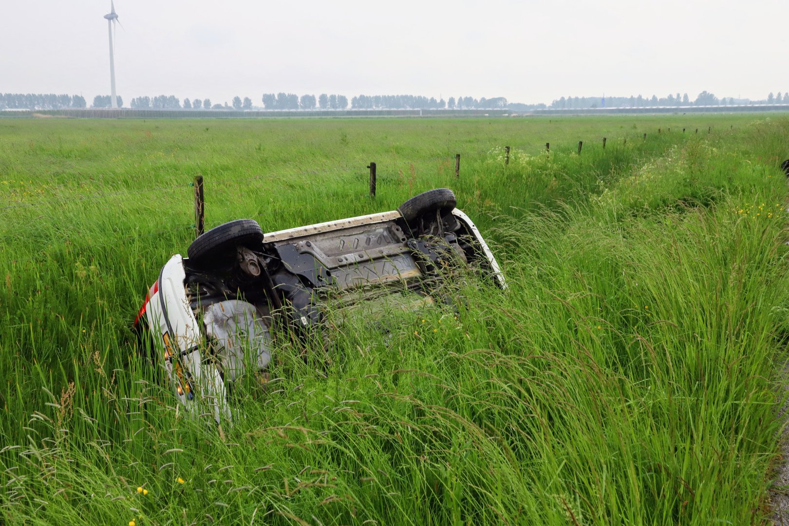 Automobiliste mist bocht de belandt op z’n zijkant in sloot