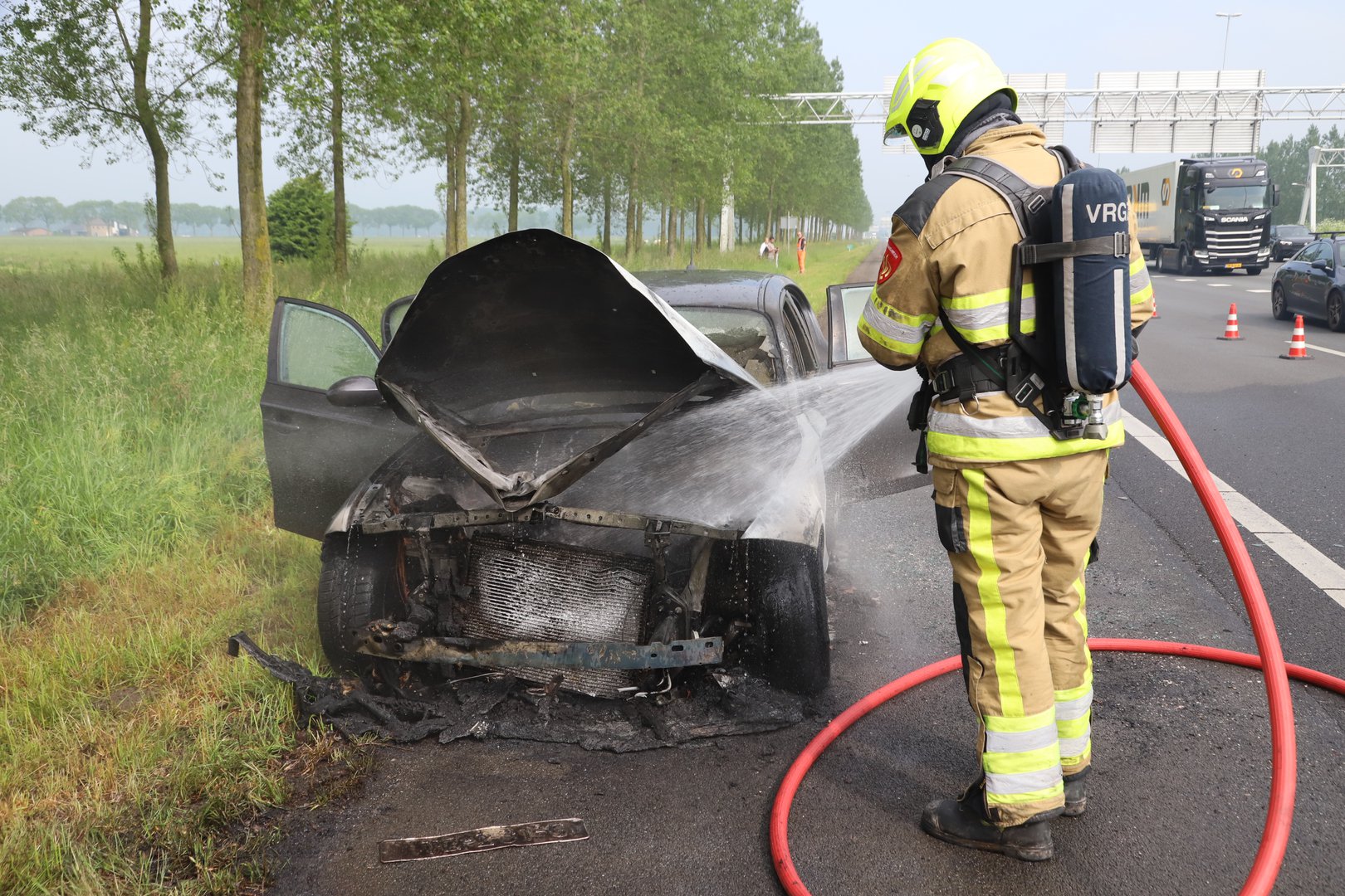 Auto vliegt in brand op snelweg, inzittenden en hondje op tijd eruit
