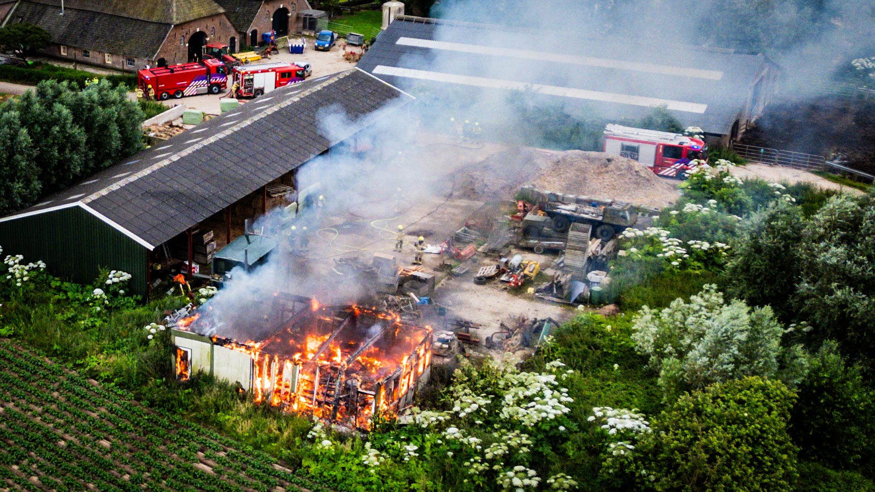 Foto update: Grote uitslaande brand in schuur, omliggende panden nat gehouden