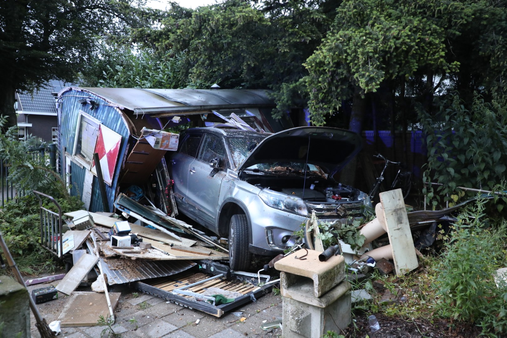 Automobilist rijdt dwars door bouwkeet