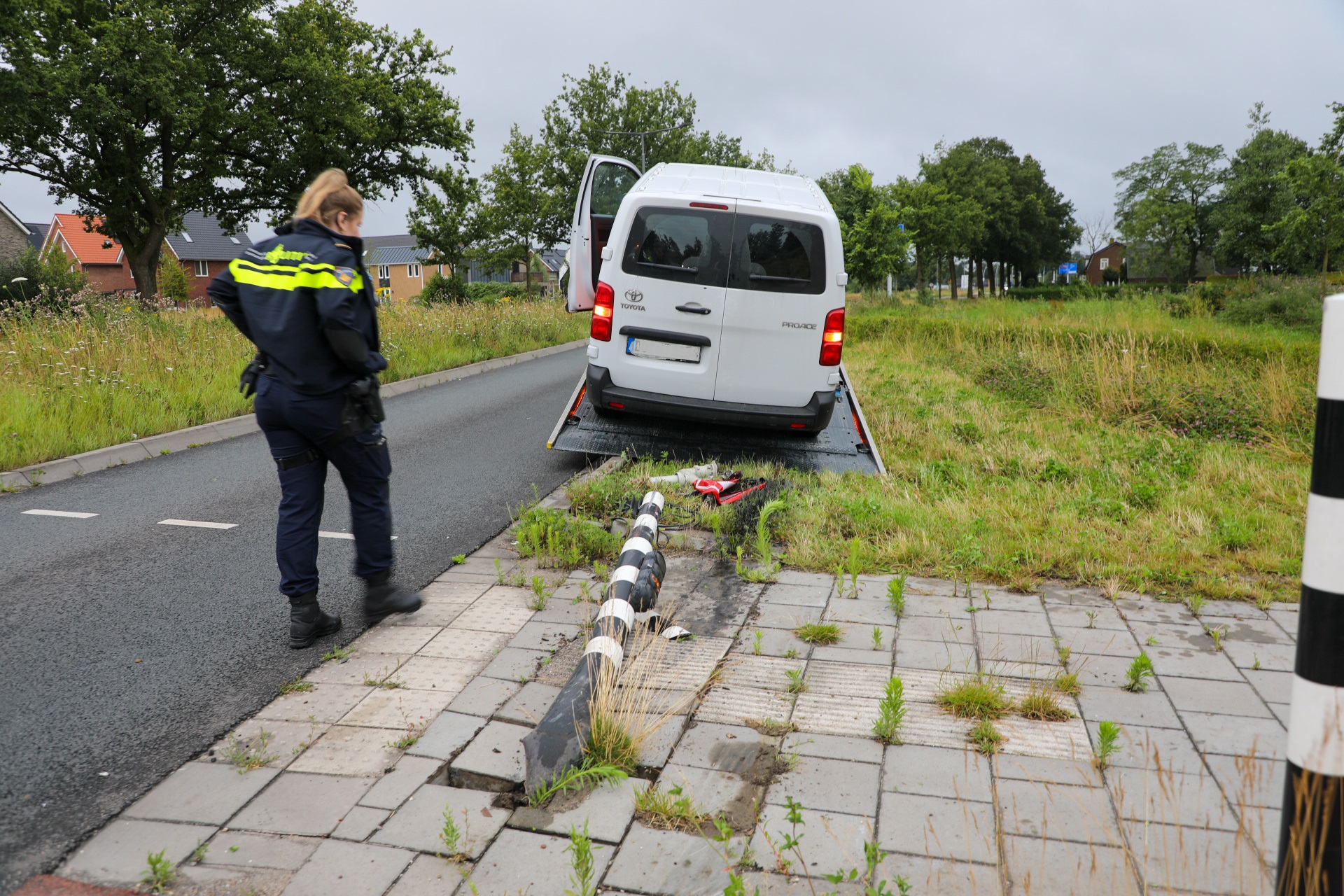 Bestelwagen ramt stoplicht, mogelijk door andere auto van de weg gedrukt