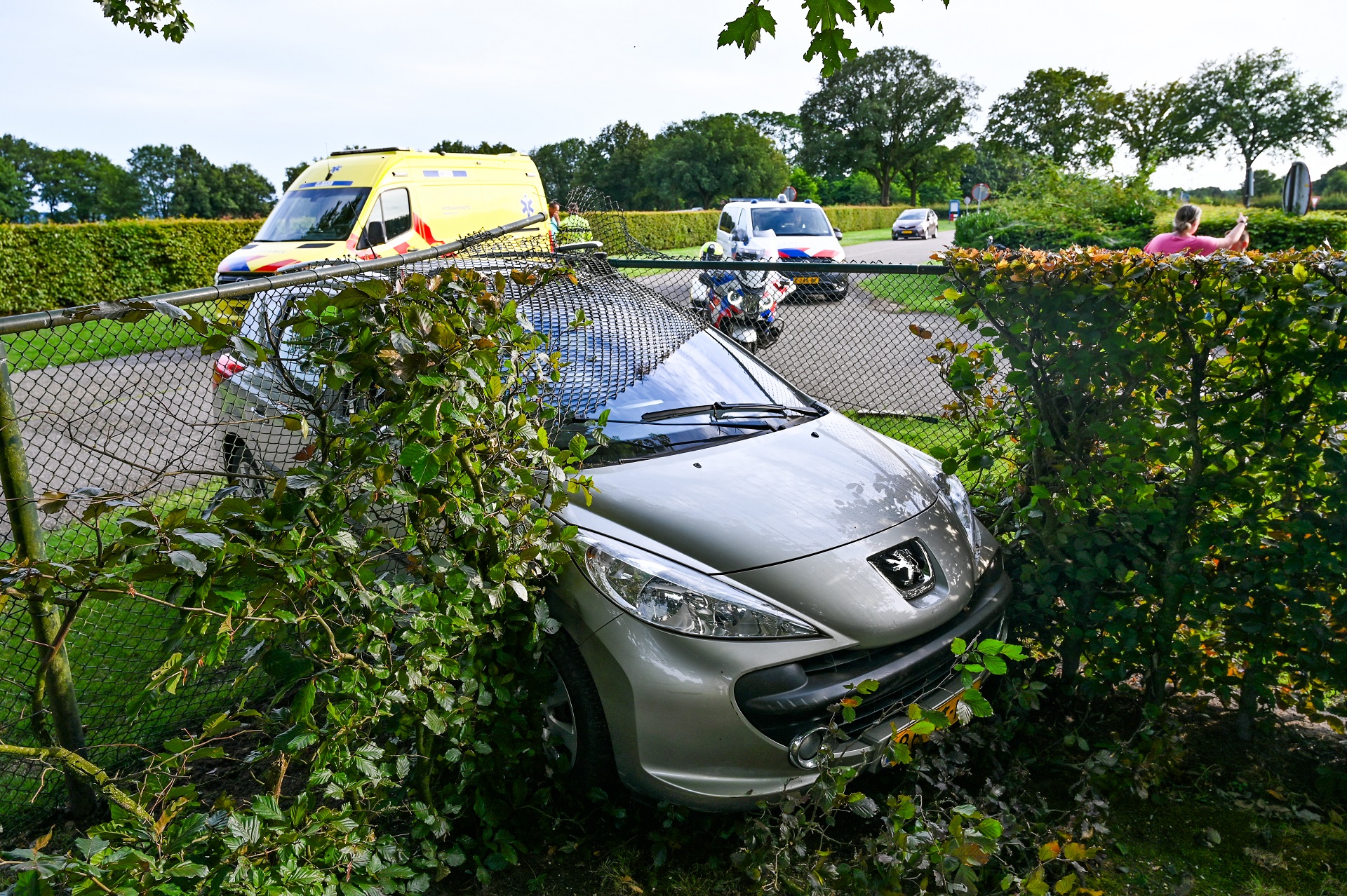Auto doorklieft hekwerk van militair kerkhof