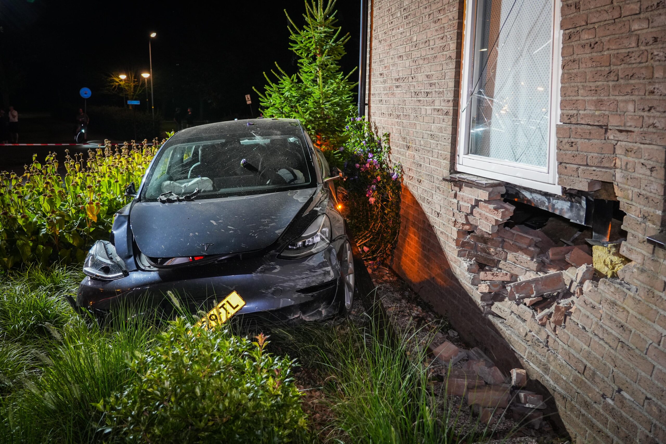 Jongeman in Tesla crasht tegen woning