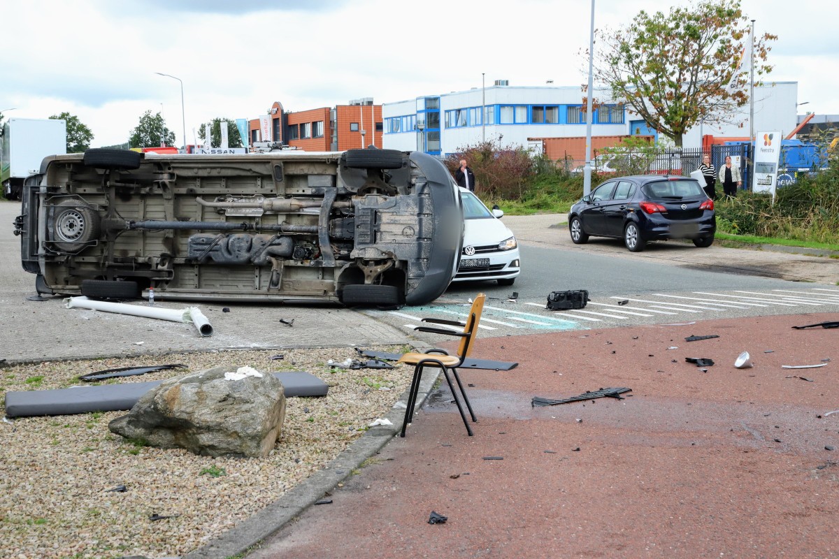 Bestelbus op z’n kant na botsing, twee gewonden naar ziekenhuis