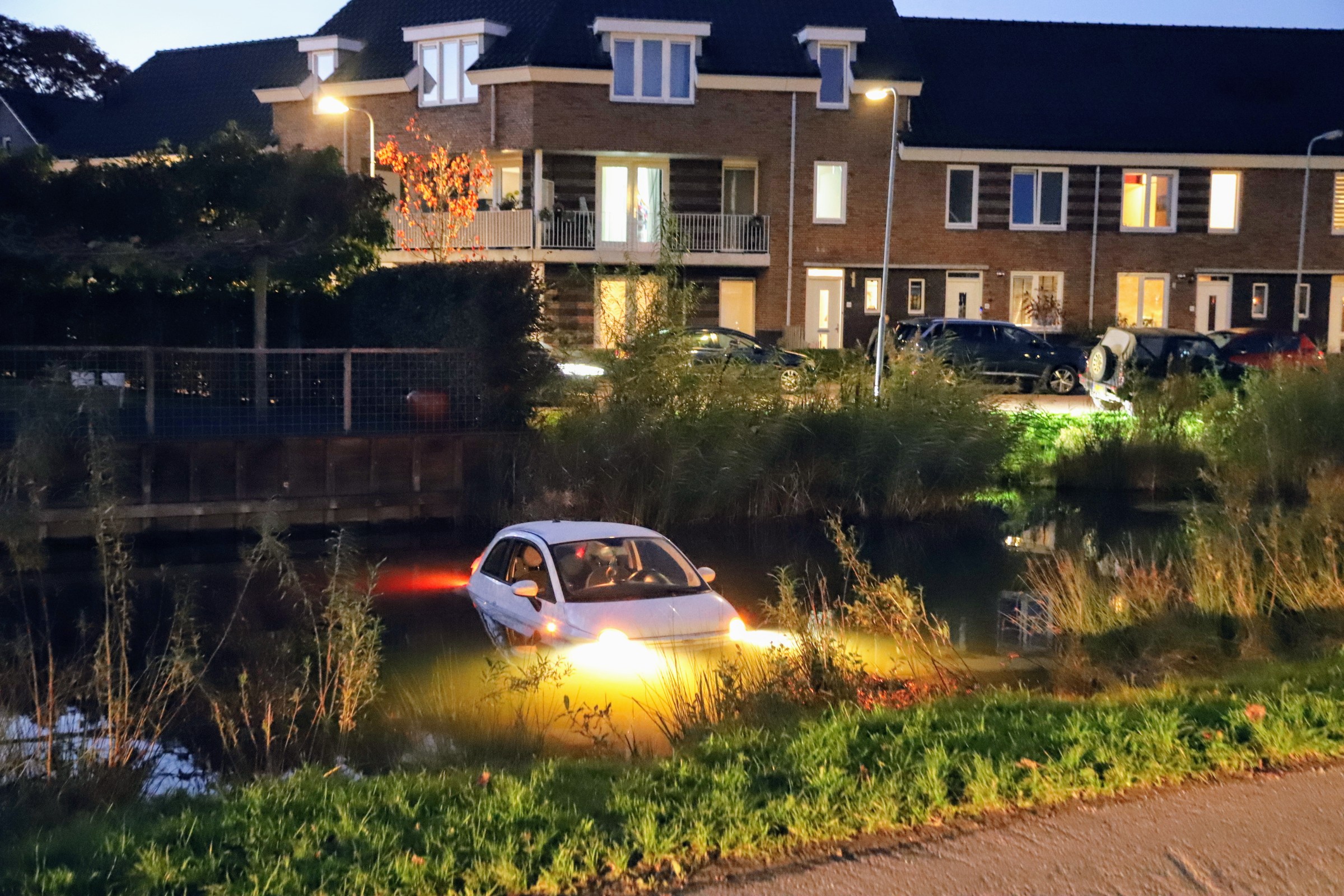 Auto rolt de oprit af, zo de sloot in