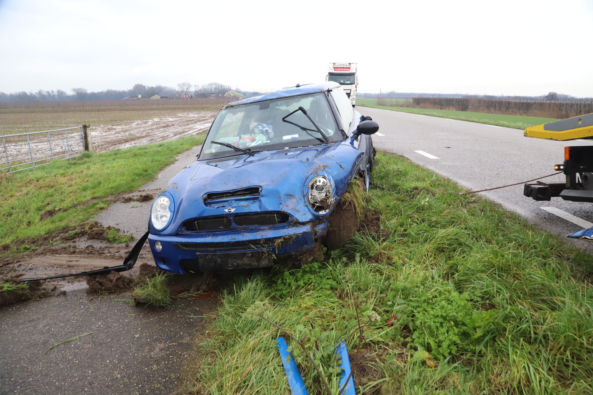 Auto belandt op de kop onderaan de dijk