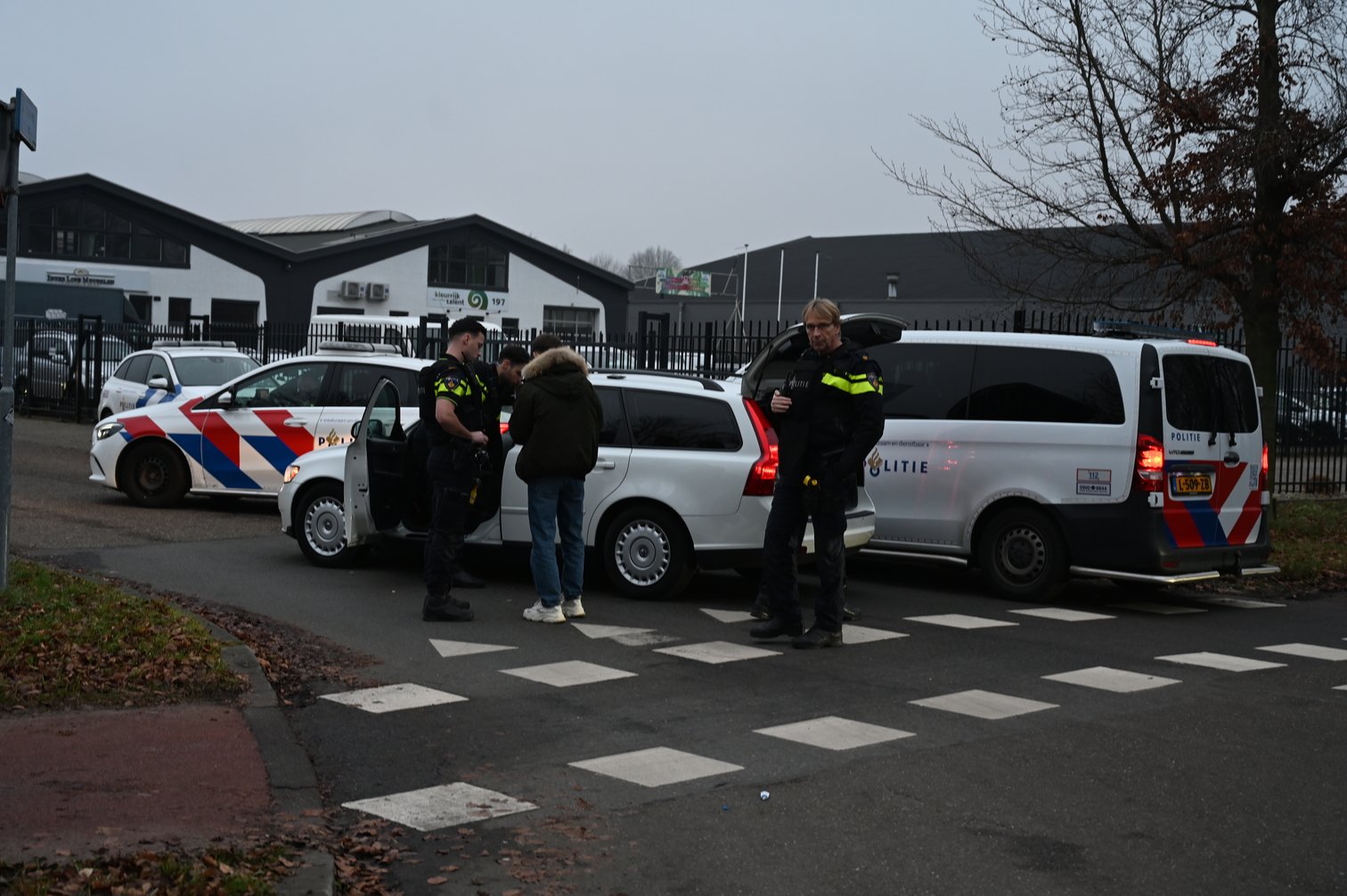 Agenten met kogelwerende vesten rijden auto klem bij binnenspeeltuin voor kinderen