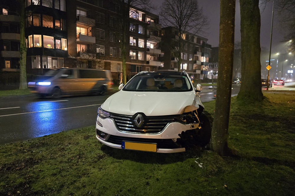 Auto ramt verkeersheuvel en komt tot stilstand voor boom