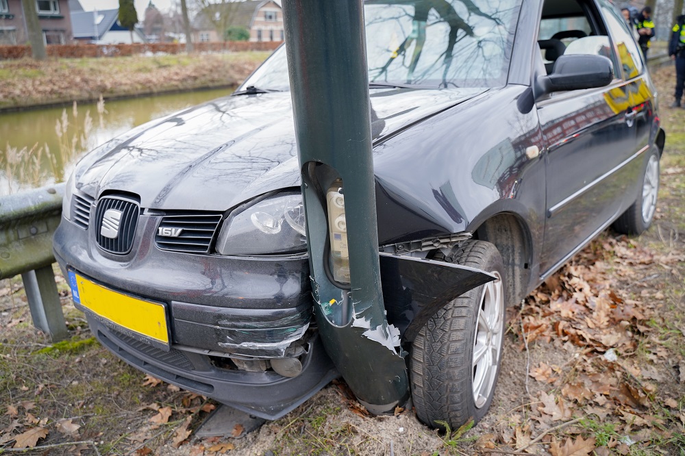 Auto ramt lantaarnpaal en vangrail