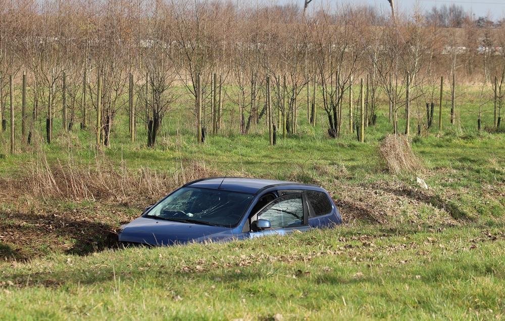 Auto in sloot langs A15, automobiliste met politie mee
