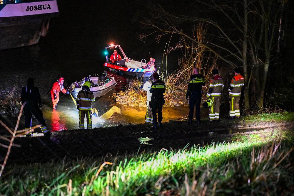 Man raakt te water en houdt zich vast aan ladder van vrachtschip