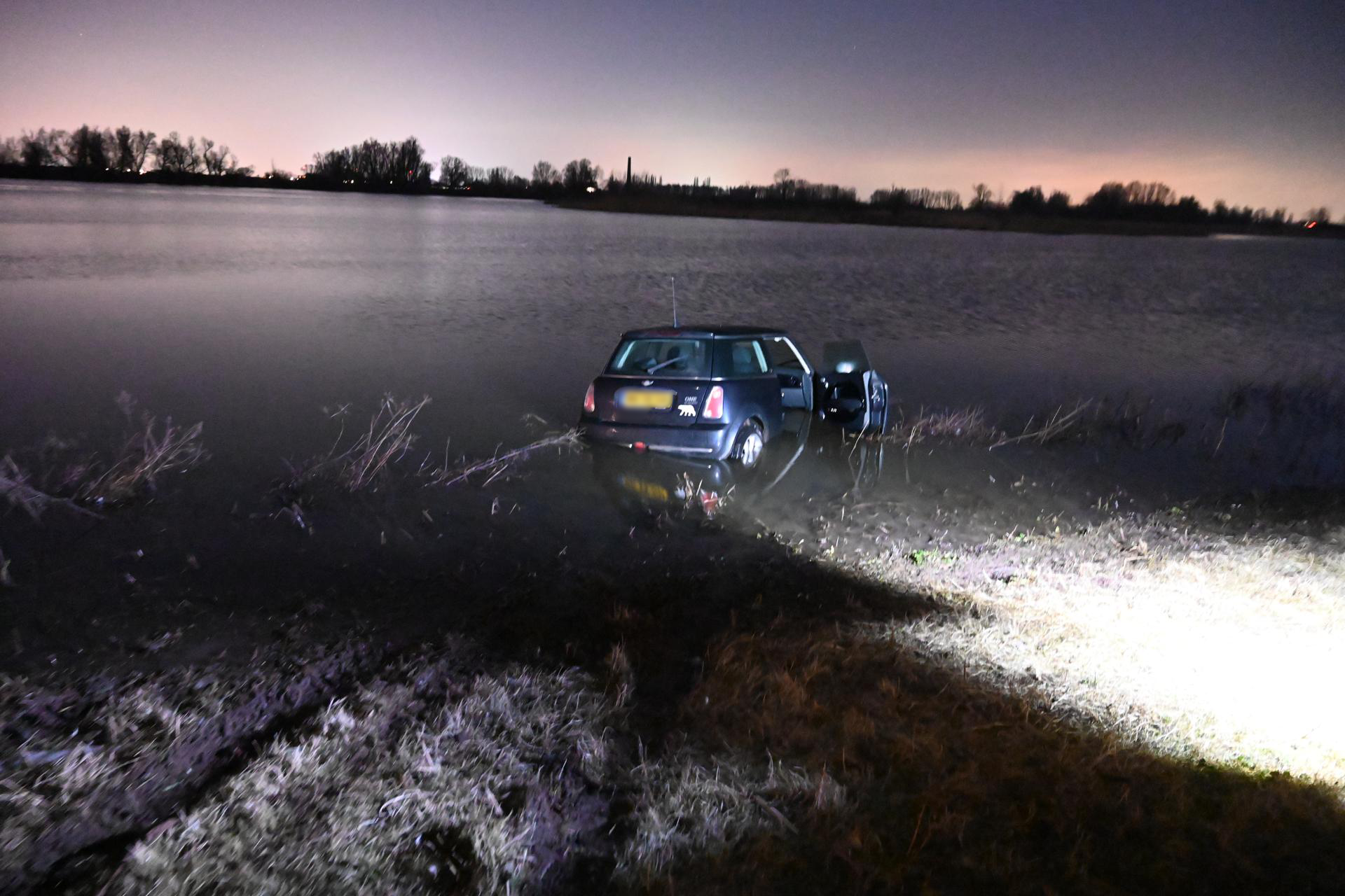 Auto raakt van dijk en belandt in water