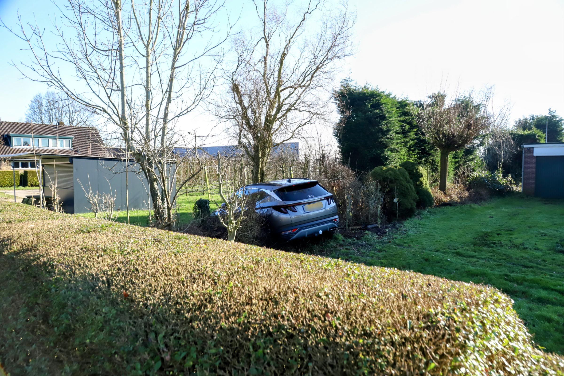 Automobilist vliegt uit de bocht en belandt in voortuin van woning