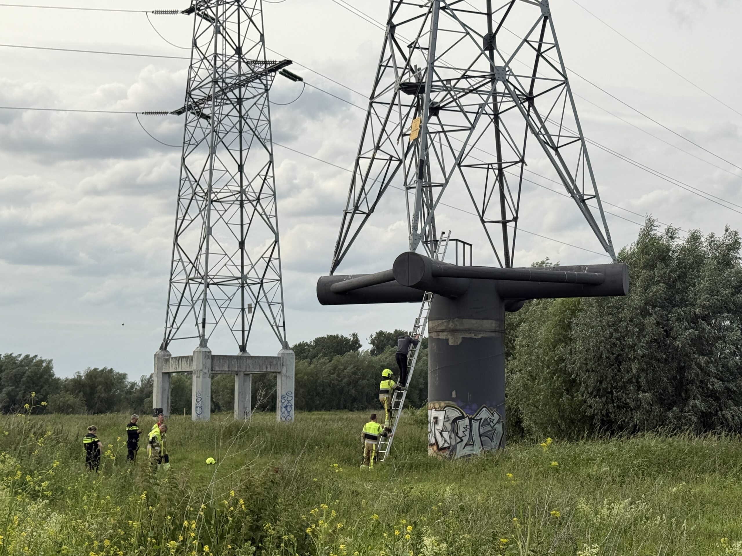 Jongeman vast in hoogspanningsmast, brandweer haalt hem veilig naar beneden