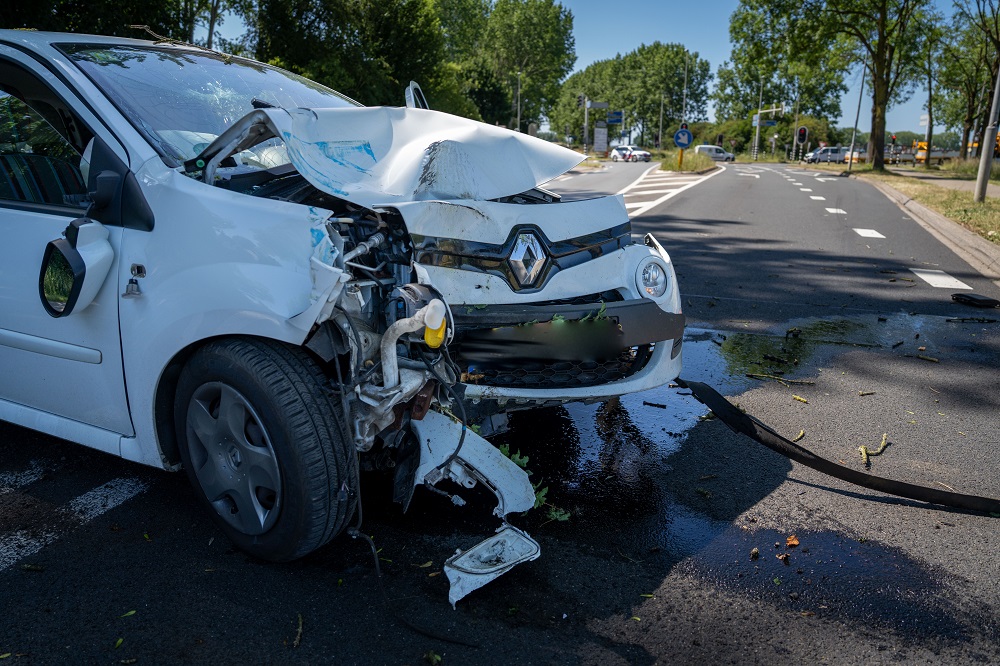 Bestuurder gewond na botsing tegen boom en verkeersbord