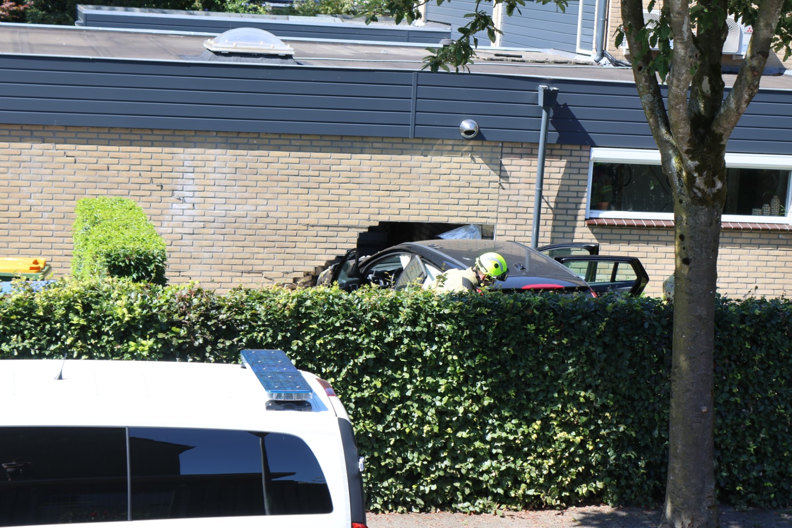 Auto rijdt door heg en eindigt in garage bij woning